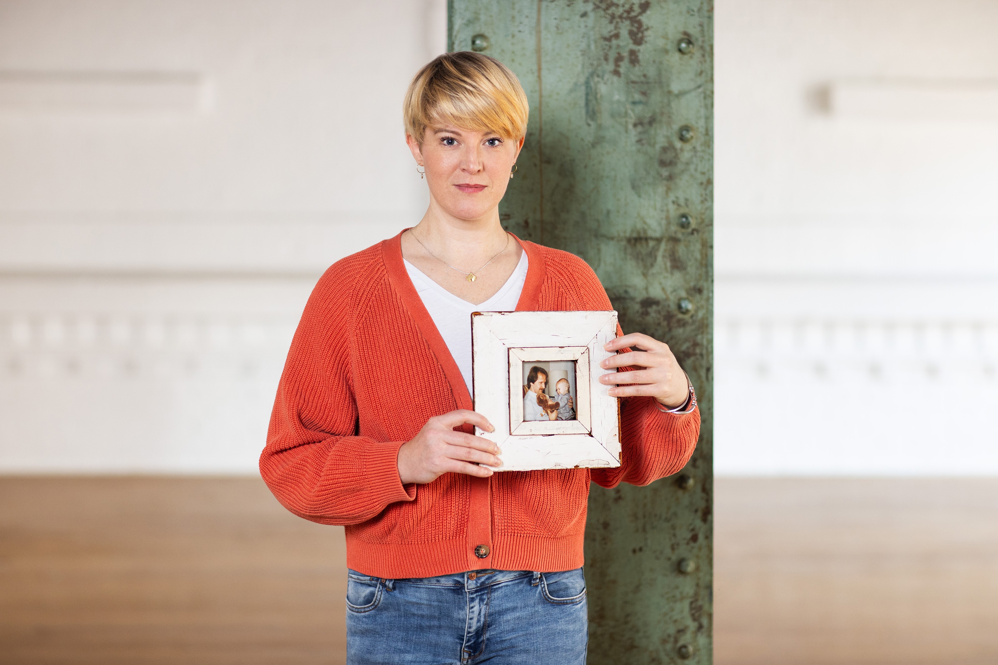 Christine Kaufmann h&auml;lt ein gerahmtes Foto in der Hand, das sie als Kind auf dem Scho&szlig; ihres Vaters zeigt. Das Erinnern, so hat sie in ihrer Ausbildung gelernt, hilft dabei, die Liebe zur verstorbenen Person aufrechtzuerhalten und sie im Herzen zu bewahren.